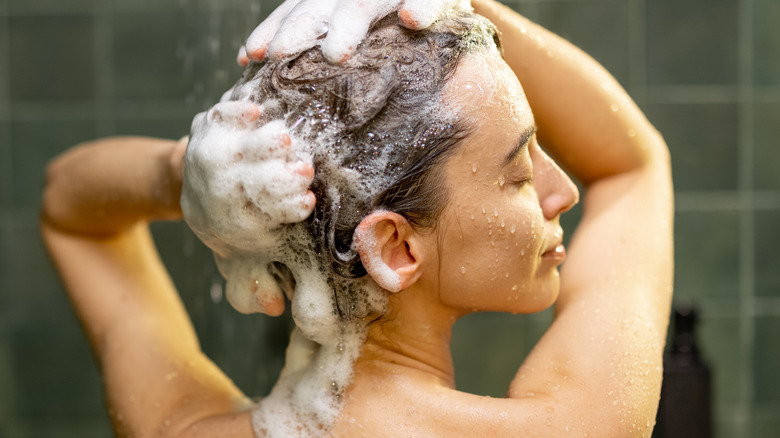 A woman shampooing her hair 