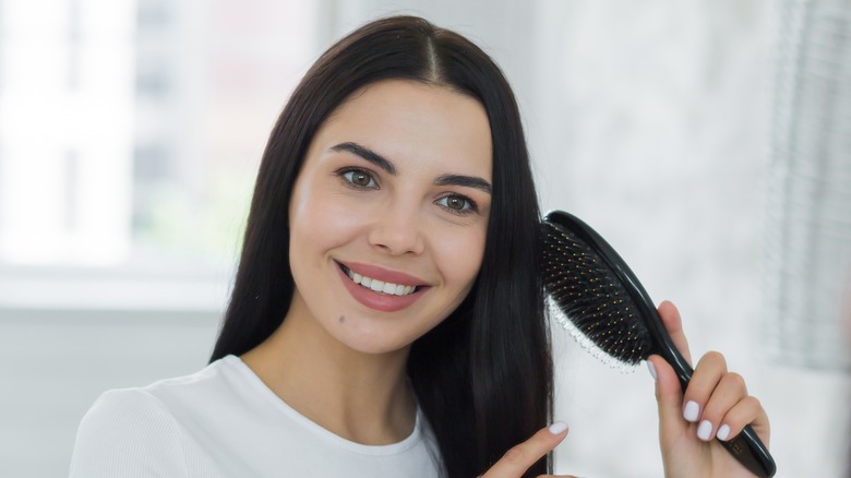 woman styling hair in mirror 