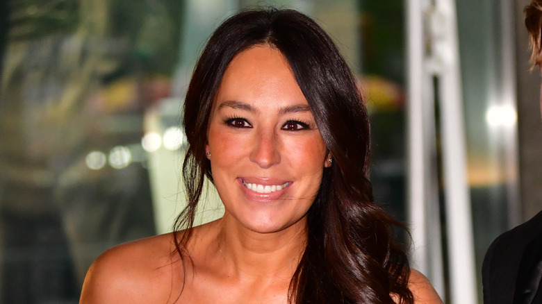 Joanna Gaines smiles while wearing her hair to the side