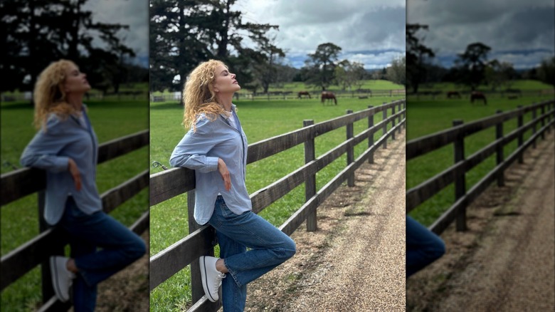 Nicole Kidman poses outside, leaning against a fence.