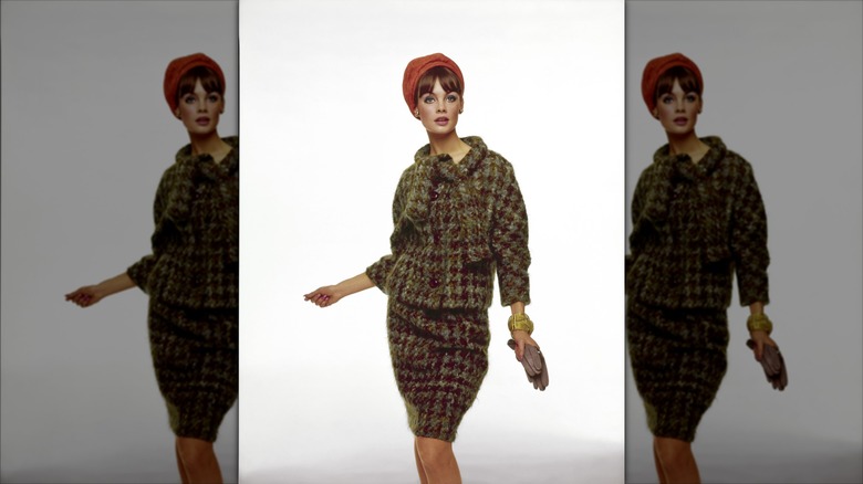 Jean Shrimpton wearing a tweed skirt suit and an orange hat