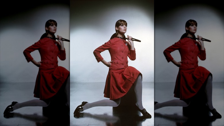 Jean Shrimpton poses wearing a red suit skirt coordinate