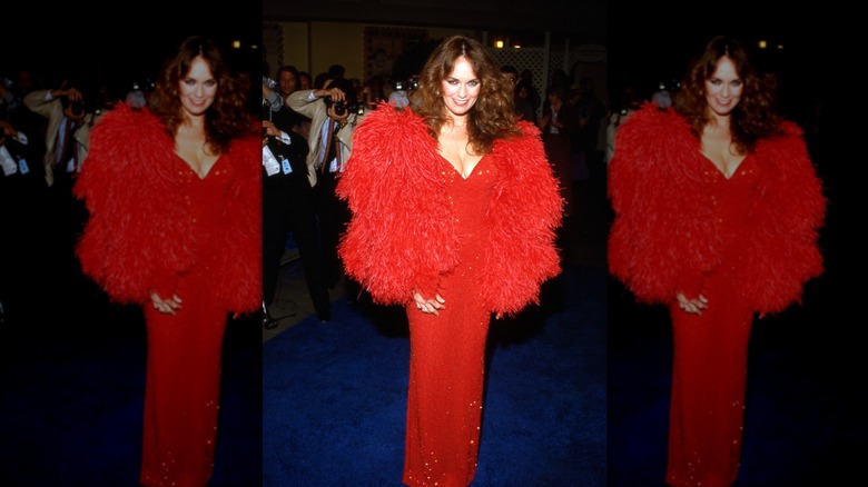 Catherine Bach smiles wearing a red sequin dress and a red fur jacket