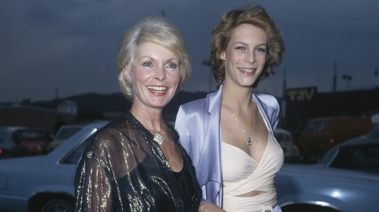 Janet Leigh wearing a shiny black top and Jamie Lee Curtis wearing a white wrapped top and lilac satin jacket at an event in September 1979.