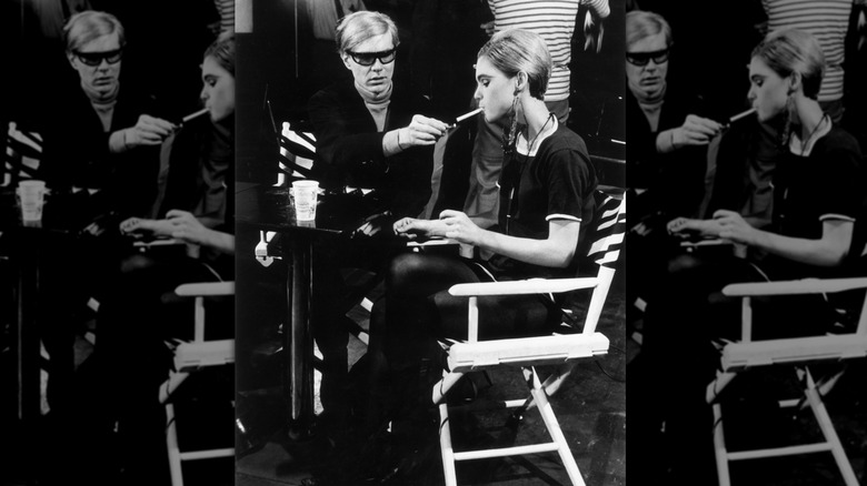 American Pop artist Andy Warhol sitting next to actor Edie Sedgwick and lighting her cigarette on the set of one of his films in 1965.
