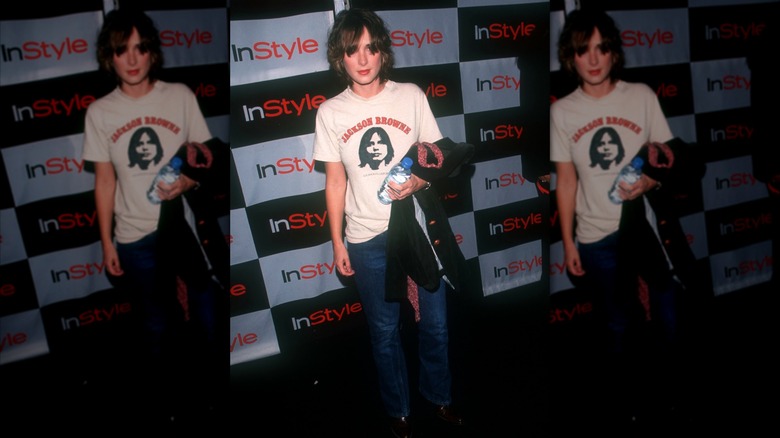 Winona Ryder posing at an event wearing jeans and a T-shirt.