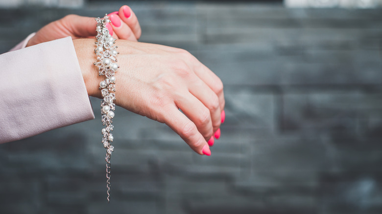 person putting bracelet on wrist