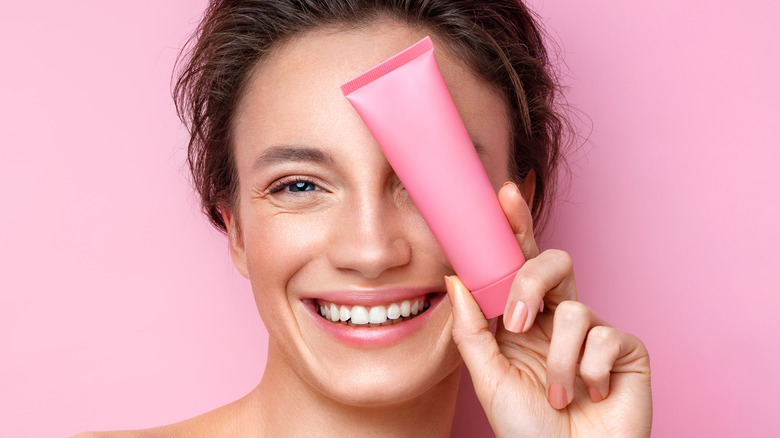 Woman holding pink tube
