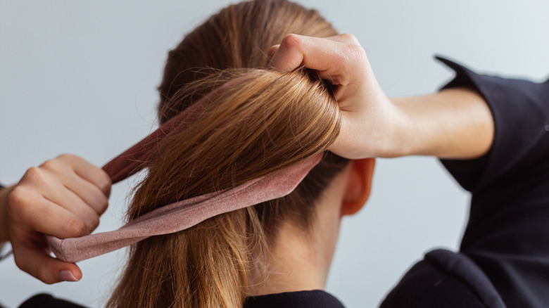 woman putting up hair