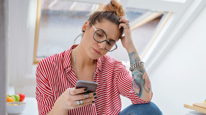 tattooed woman with phone