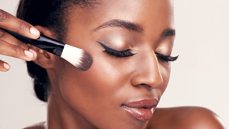 Woman applying blush with brush