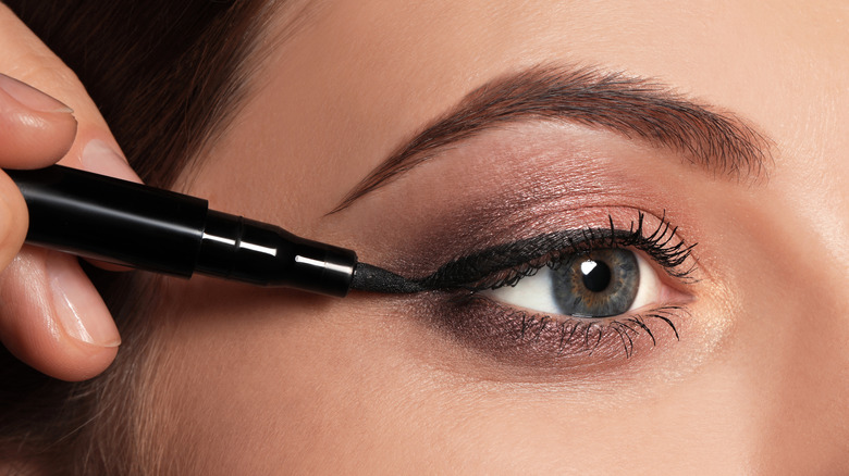 Woman applying eyeliner