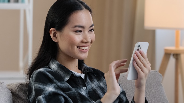 smiling woman using smartphone