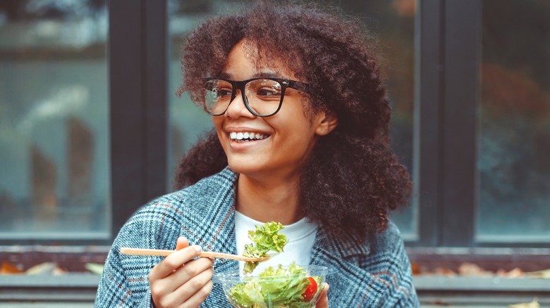 woman happily eating a salad
