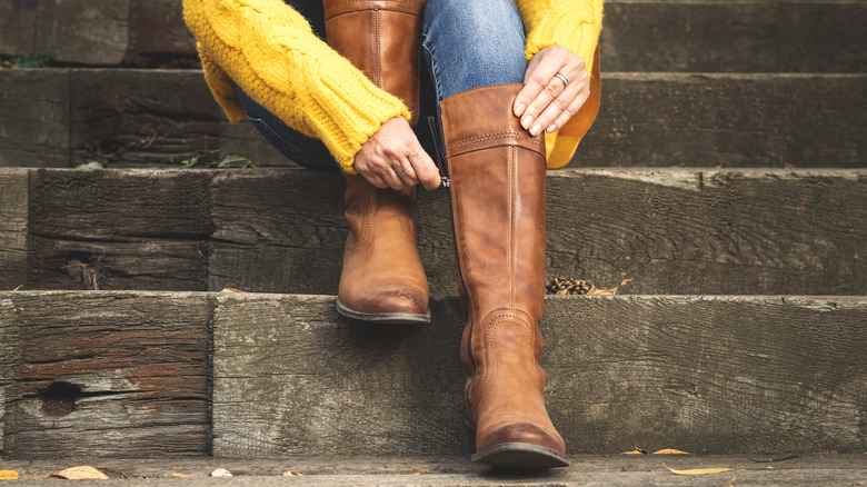 person putting on riding boots