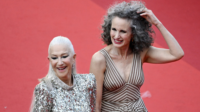 Helen Mirren in a sparkly silver dress and Andie McDowell in a brown-and-white striped dress.