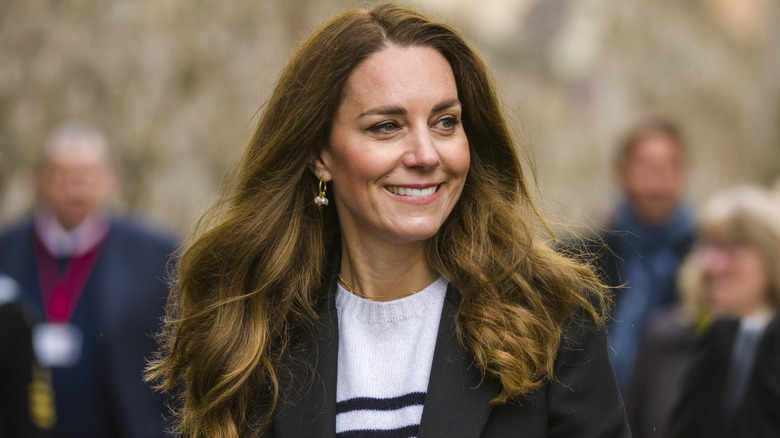 Kate Middleton with her regular brown hair wearing a knit sweater and a blazer