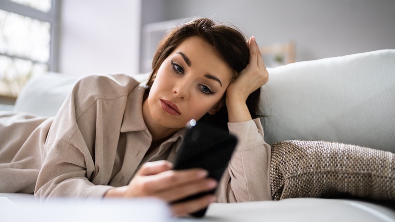 Closeup of handing holding phone displaying Tinder app 