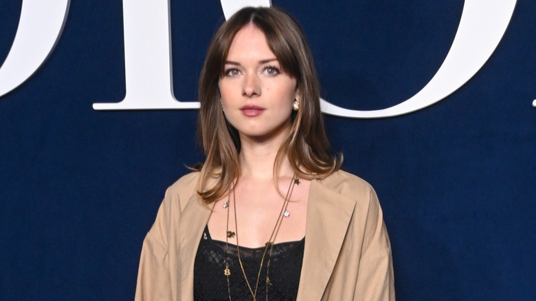 Stella Banderas wearing a black top with a beige jacket at an event in 2024.