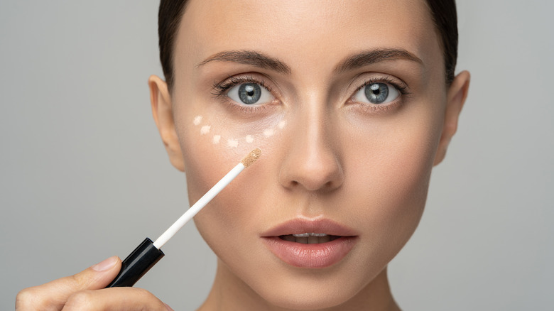 Woman applying concealer