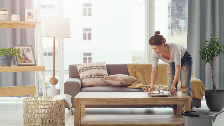 Woman tidies living room