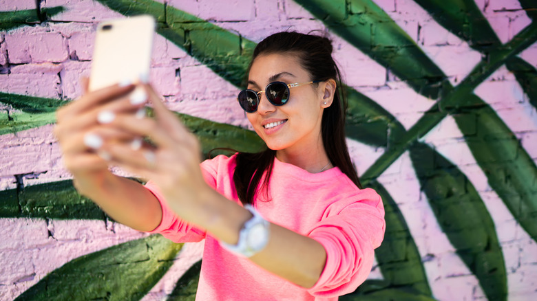 woman taking selfie video with phone