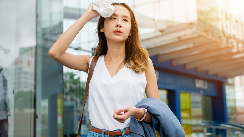 woman using a cloth to wipe sweat