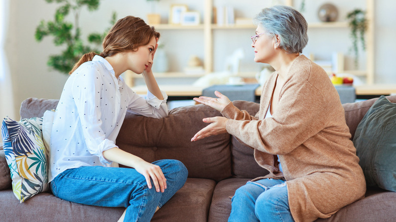 Woman and mother arguing on couch