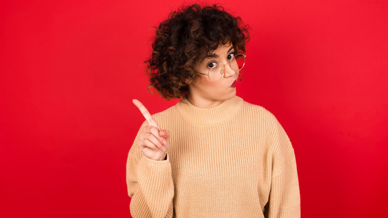 Woman with finger up, saying "no"