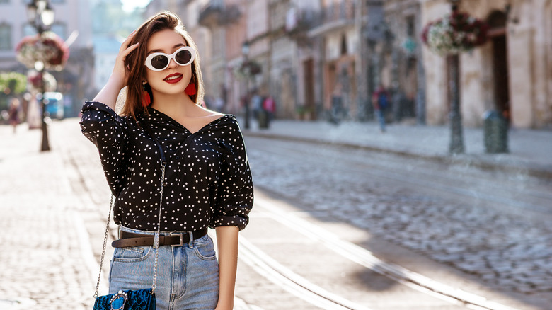 Woman in sunglasses on sidewalk 