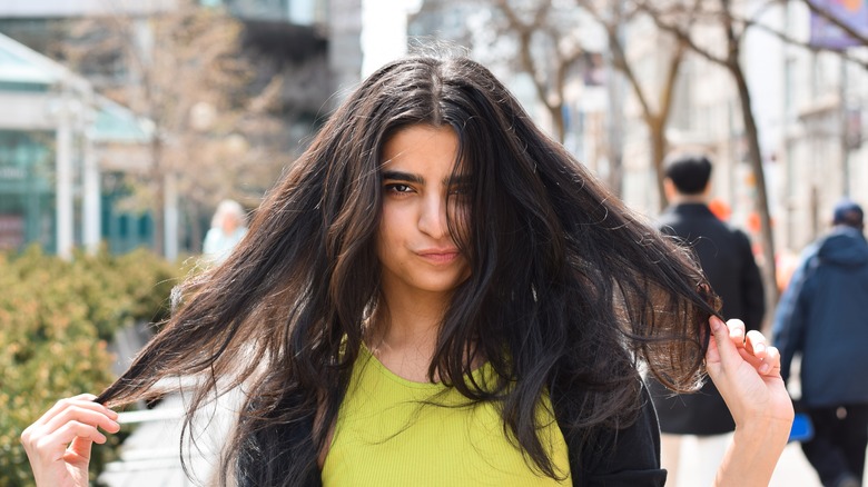 Woman in street holding her messy hair 