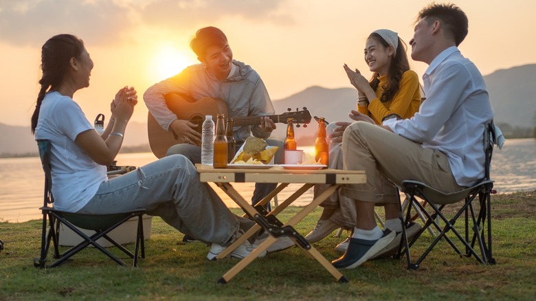 friends camping and listening to guitar