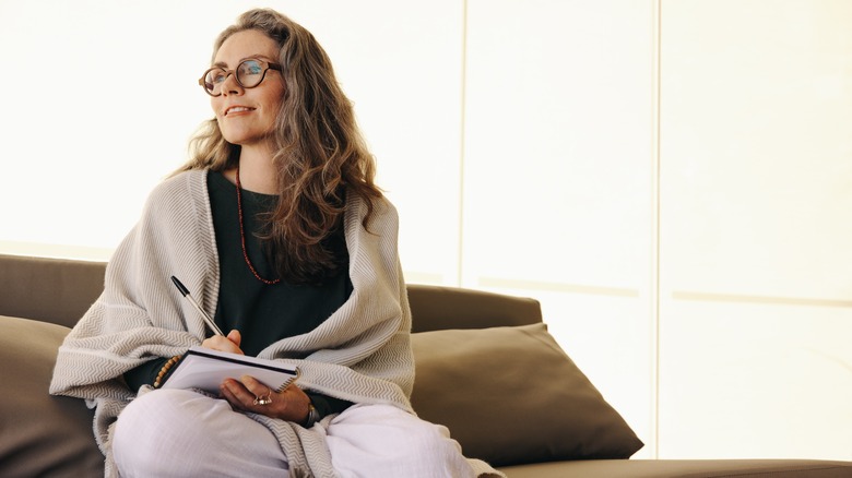 Woman journaling on couch