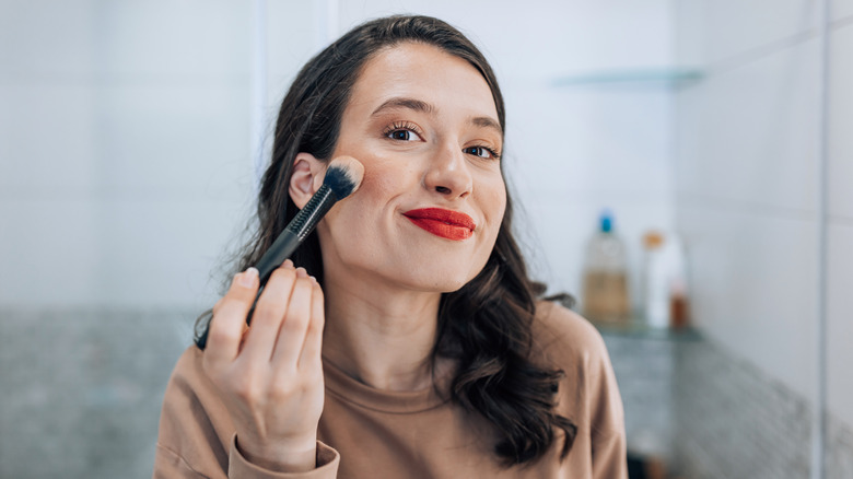 Woman applying blush