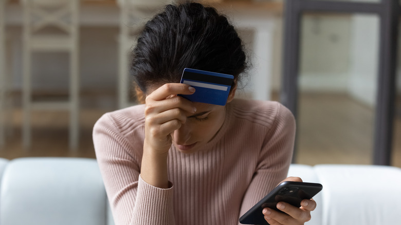 woman stressed holding credit card