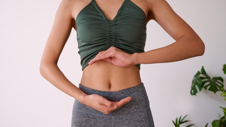 Woman cradles midriff 