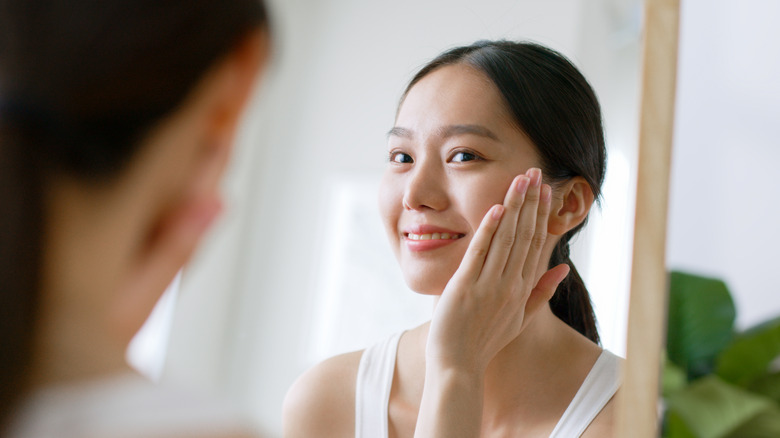 Smiling woman touching face