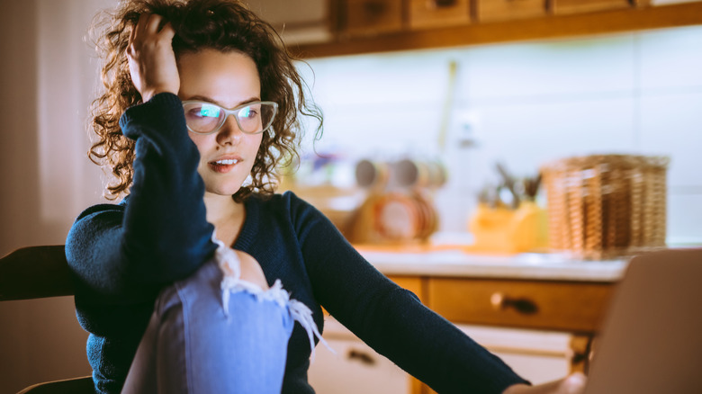 woman at laptop biting lip