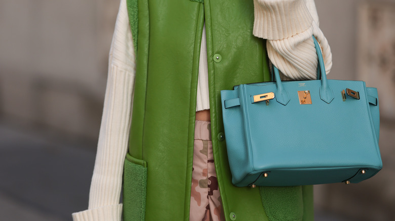 model holding blue Birkin bag