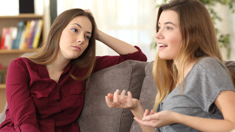 Woman looking bored while friend talks
