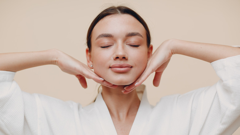 woman holding hands under jaw