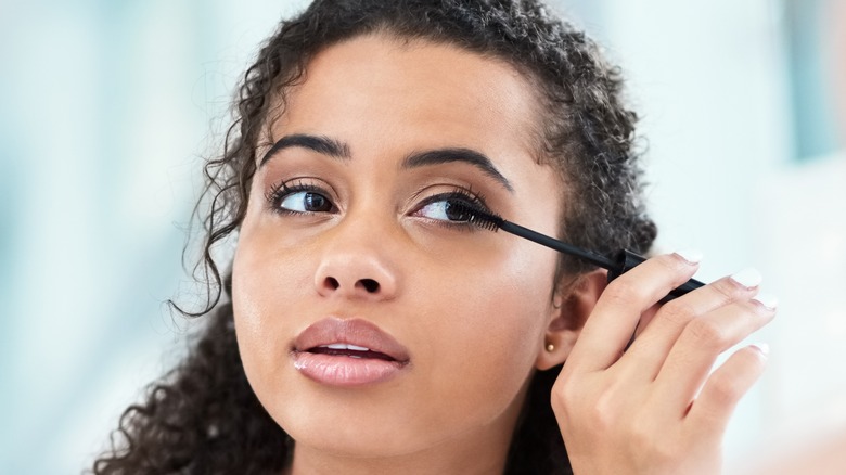 female applying mascara