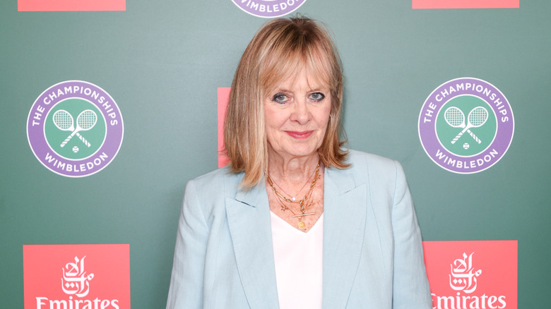 Twiggy posing at an event in 2025 wearing a white top and light-blue blazer.