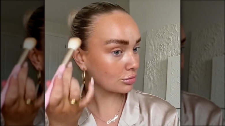 woman applying bronzer to eye