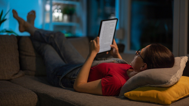 Woman reading on her Kindle on the sofa