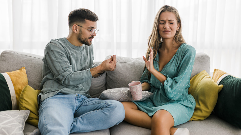 Man and woman arguing on couch