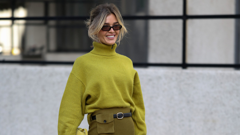 A woman posing in a chartreuse green sweater