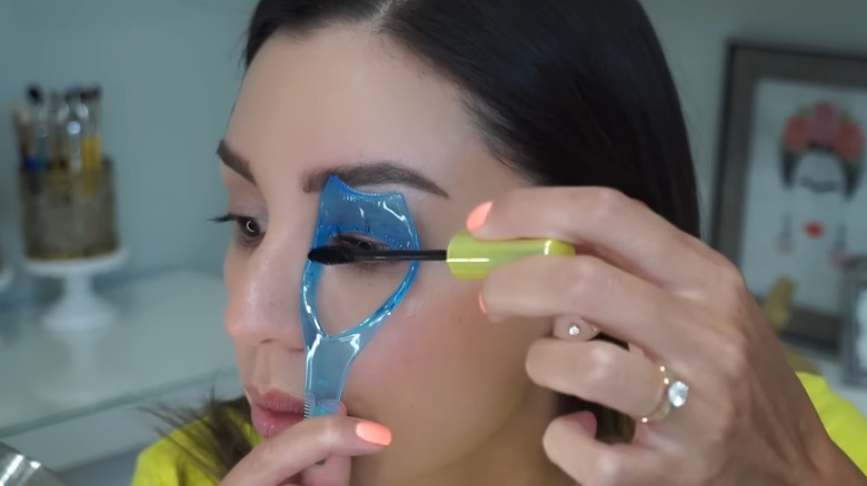 Woman using a mascara shield