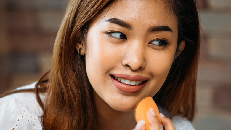 woman using makeup sponge