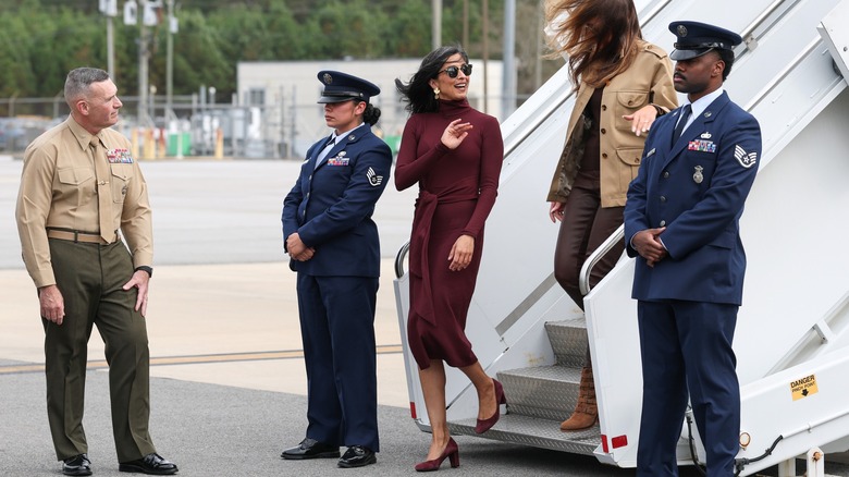 Usha Vance in a burgundy dress with Melania Trump behind her